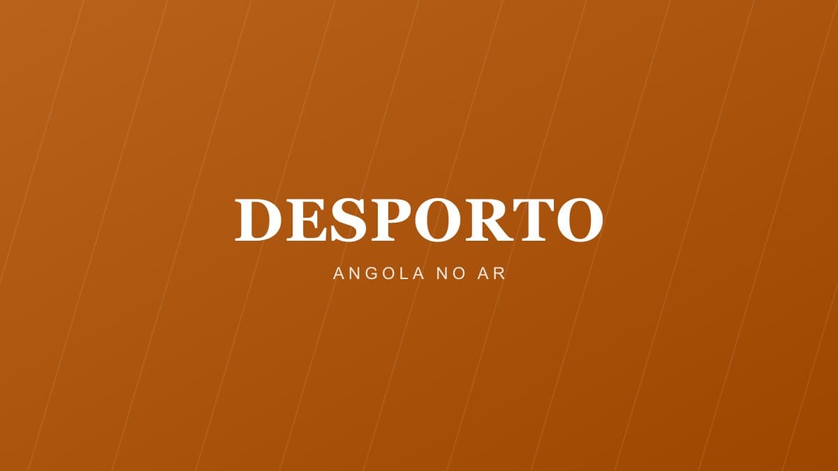 Estádio lotado com adeptos de dois clubes rivais durante um jogo de futebol em Angola, com iluminação natural e ambiente desportivo intenso